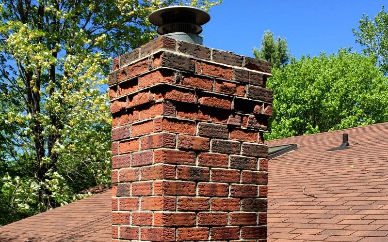 Close up of the top of a brown brick chimney